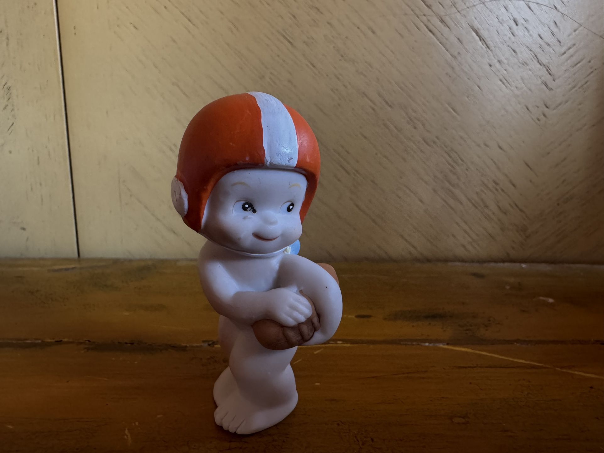 Lefton Kewpie doll, possibly a football-themed version. These dolls were originally made of bisque porcelain