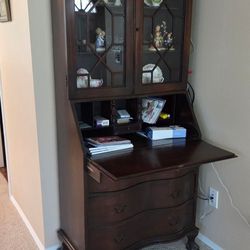 Antique secretary, dark wood, 3 drawers, 3 shelves behind glass doors and fold down
desktop. Very good condition. Measures: L29.5 x W 15" x H 78"
