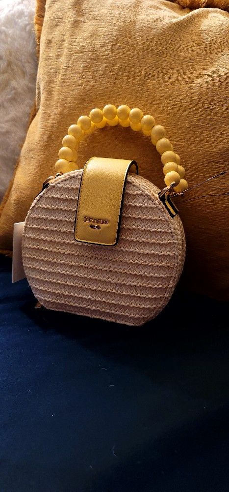 Dune London. Is beautiful Dune purse with yellow bead handle and a yellow strap, it is made of wick with a black interior and the Accents on the purse