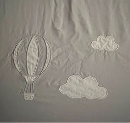New custom made embroidered crib sheet in gray cotton with hot air balloon and clouds sewn on