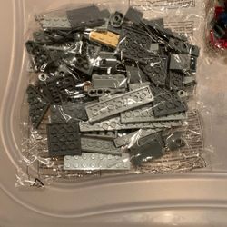 This is a bulk lot of assorted gray LEGO bricks and pieces.  The lot includes various brick types, such as plates, slopes, and specialty pieces.  The 