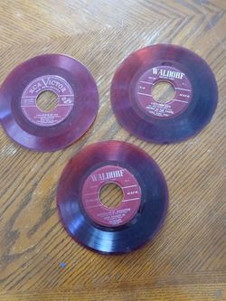 Old red colored 45 size records,three of them total. Wall hangers, slightly warped,great for 50,60s era themed atmosphere..