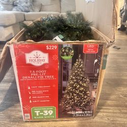 Christmas tree with a box of Christmas ornaments recently purchased at Hobby Lobby.