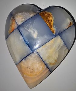 **This vintage blue, cream, and white heart-shaped stone paperweight features a distinct checkerboard