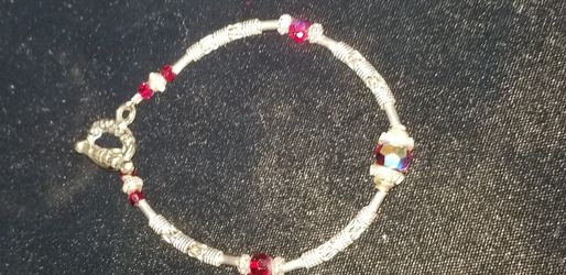 Artisan bracelet, silver bali-style & red iridescent crystals