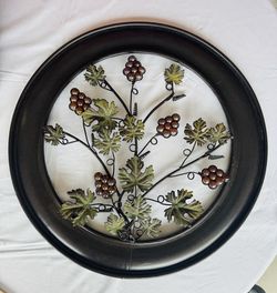 Home decor round rod iron wall hanging of grape leaves design.