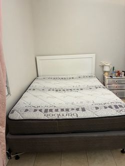 White bed frame with mattress and box spring
