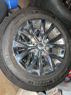 A set of Ford F-150 OEM 20-inch PVD chrome wheel (Hollander 10003) wrapped in a Michelin Defender LTX M/S 275/55R20 tire.