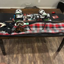 Ride Agenda snowboard equipped with bindings and goggles