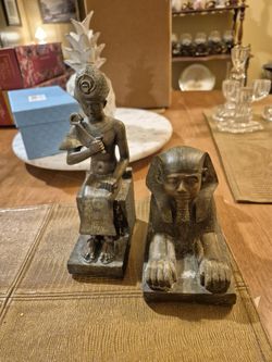 Two egyptian statues, one of sphinx and the other of a pharaoh