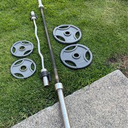 Olympic weights 2x35, 2x10 lbs with curling bar and 7 ft 45 lb barbell