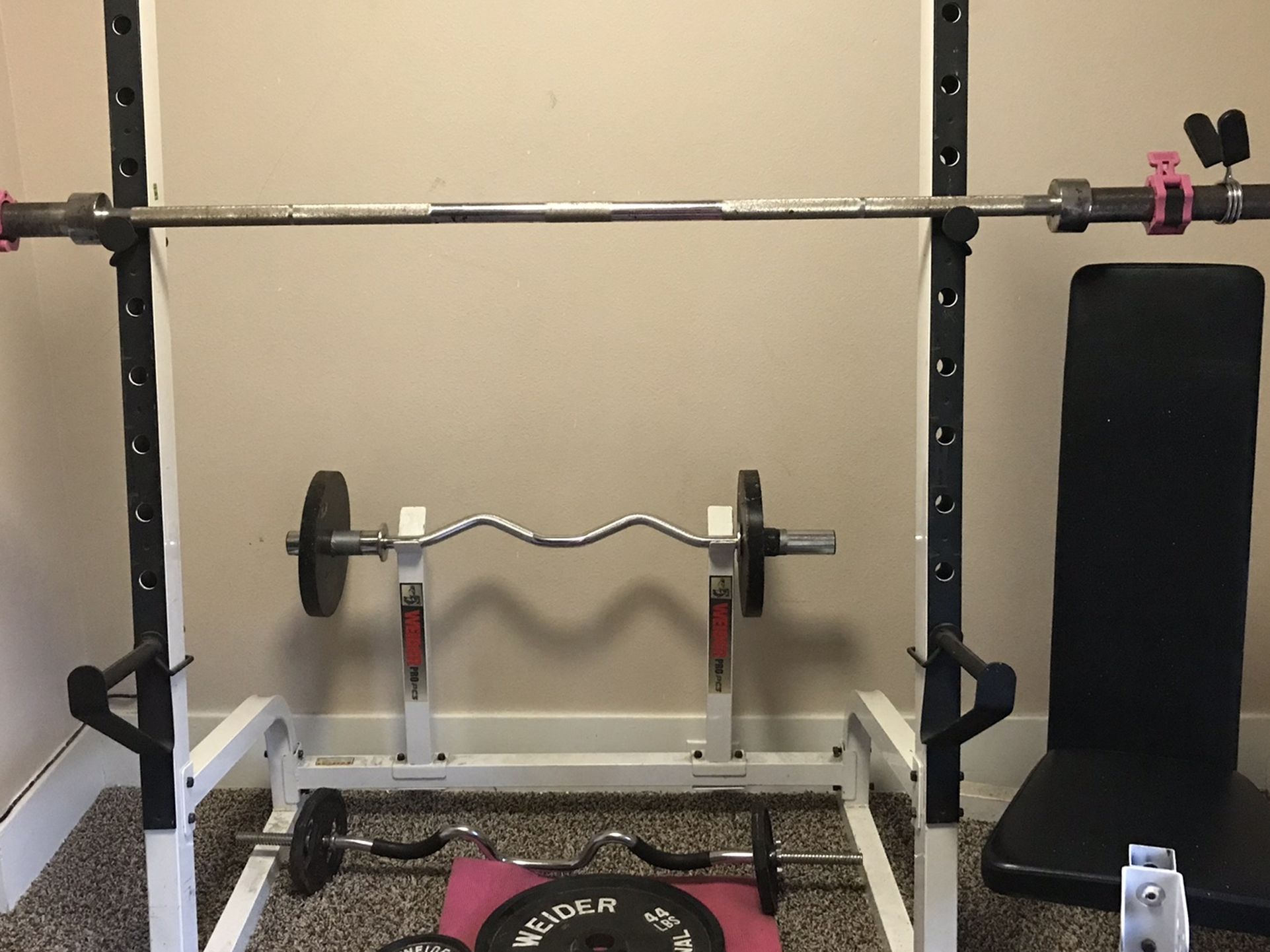 Home gym: squat rack with Olympic barbell weight set, curl bars, adjustable dumbbell set and adjustable bench