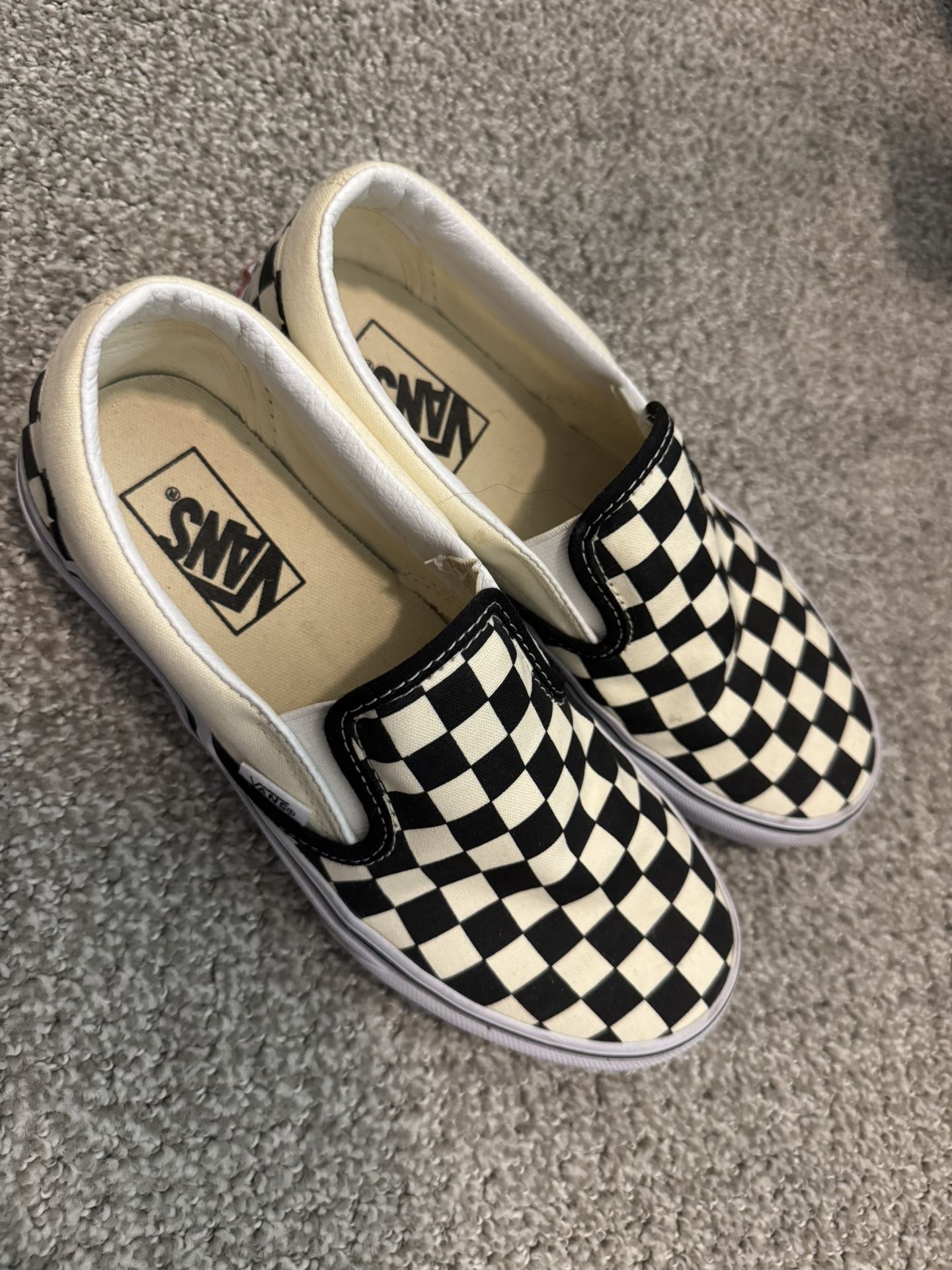 Classic Vans slip-on shoes with a checkerboard pattern. WOMEN 7.0 MEN 5.5