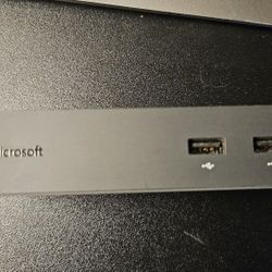 The Microsoft Surface Dock (Model 1661) is a black, magnetic docking station designed to transform Surface devices into a desktop workstation, featuri