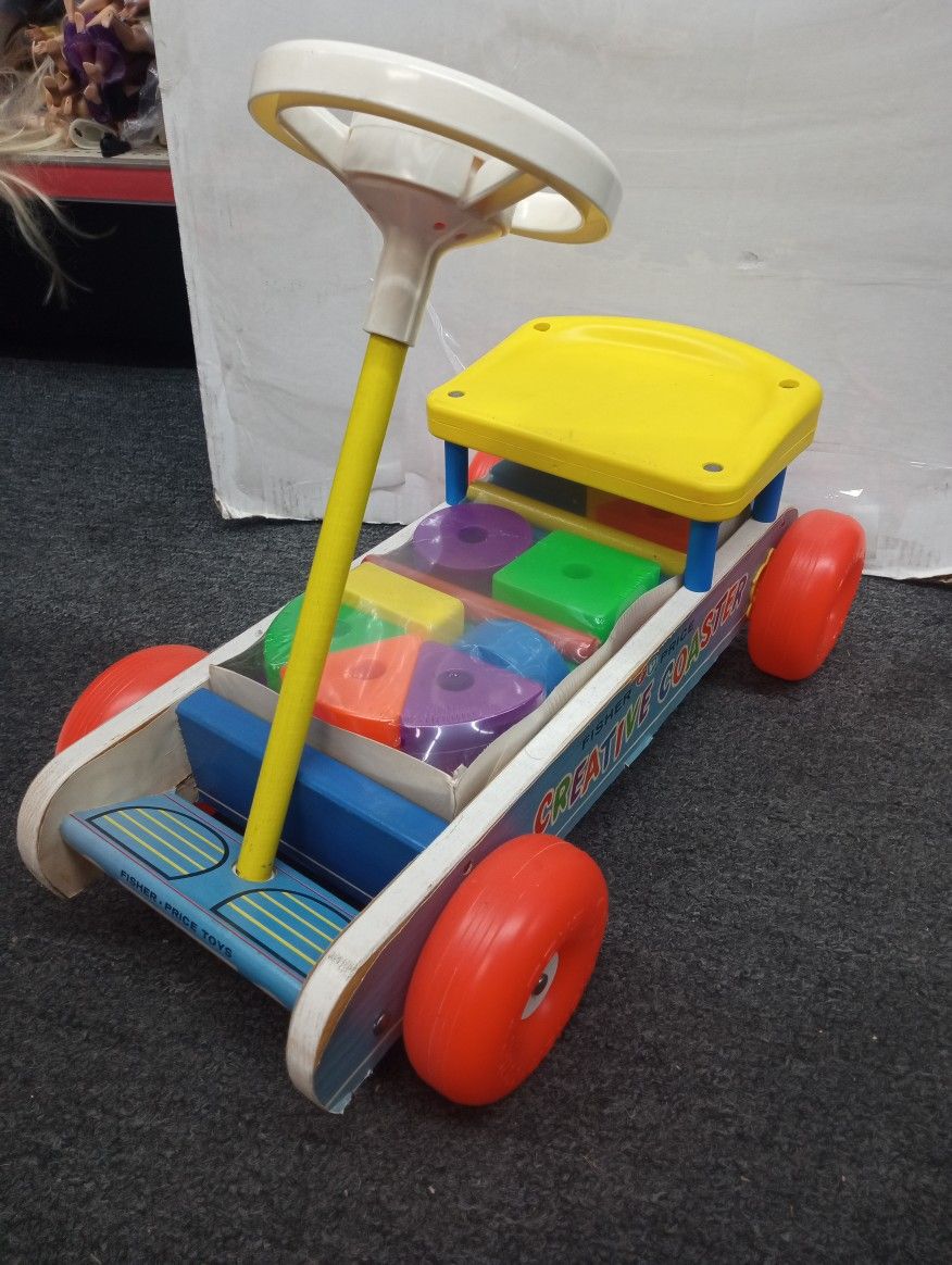 Vintage Fisher-Price Creative Coaster, likely from the 1960s or 1970s. It's a ride-on toy designed for young children, featuring a wooden frame, a yel