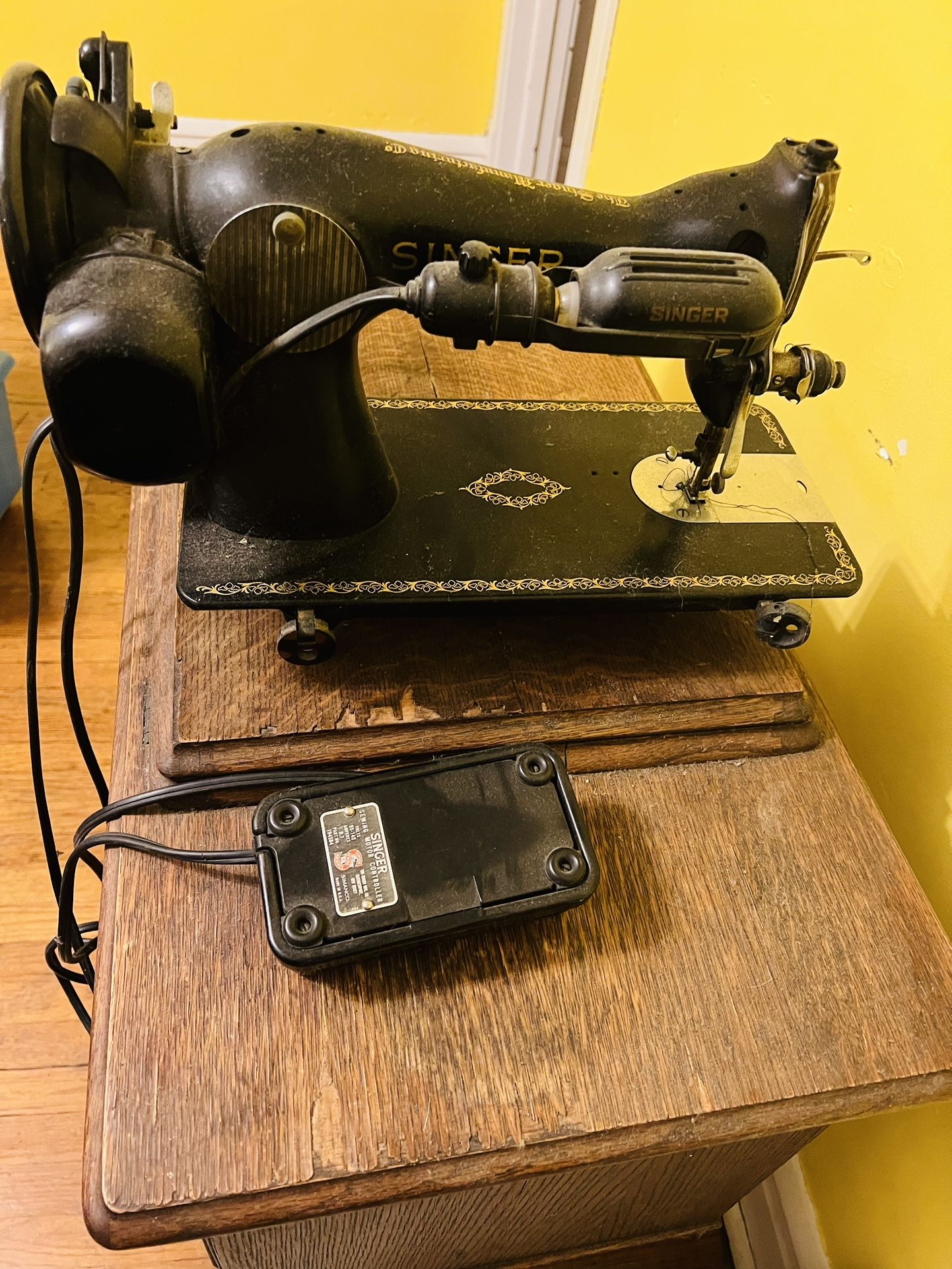 vintage Singer treadle sewing machine with electric motor and wooden cabinet