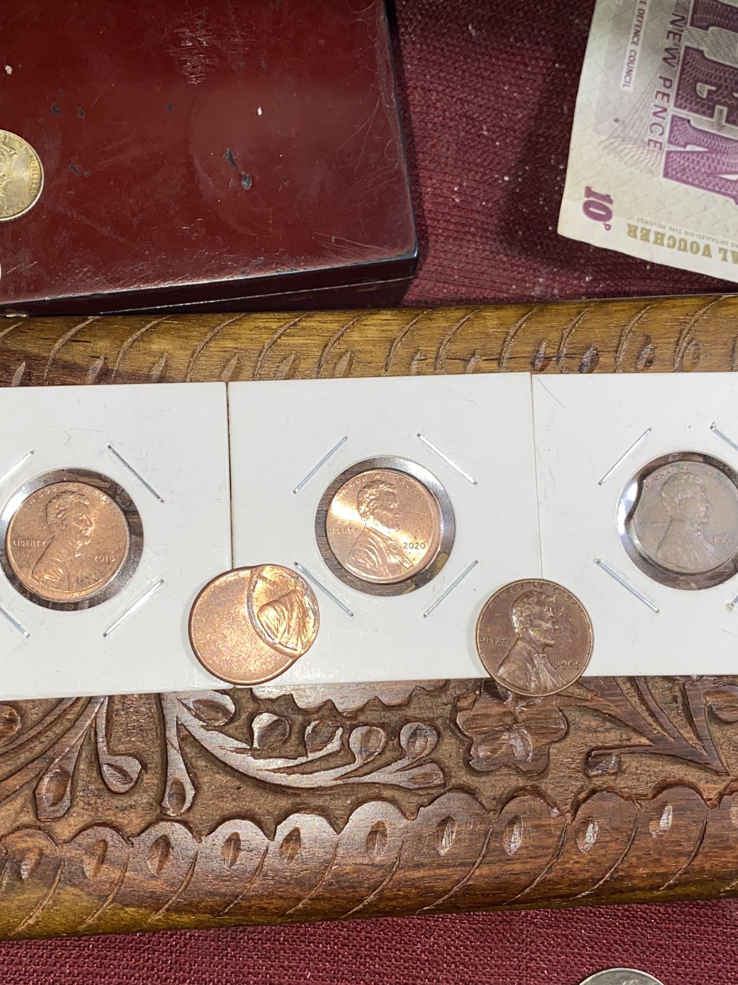 Three off-center copper pennies one 1965 red penny and one 1962 error duringclip
