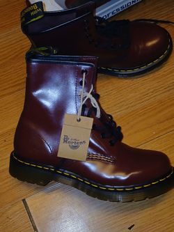 These are Dr. Martens 1460 Cherry Red boots featuring smooth leather and yellow stitching.