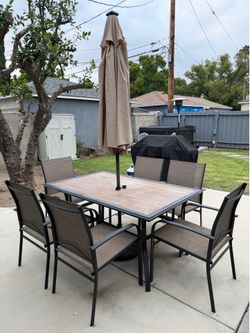 Patio set with six chairs, table, and umbrella