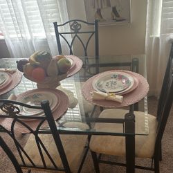 Dinette set with glass table and four chairs for sale