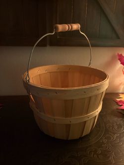 natural wood bushel basket featuring vertical wooden slats and a wire handle with a wooden grip