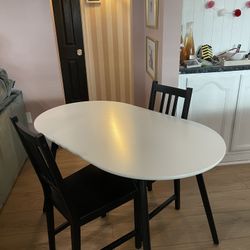 White oval dining table with two chairs