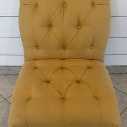 Yellow tufted chair with wood legs