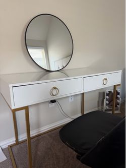 Gold trim, white desk, and round mirror