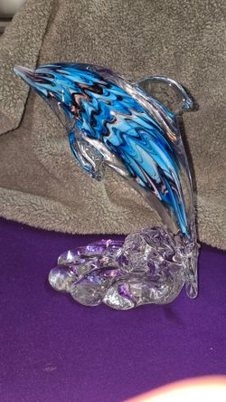 Dynasty Gallery Blue Swirl Art Glass Dolphin On Clear Gass Base  R1U008
Our glass rendition of the iconic dolphin showcases this beautiful sea creatur