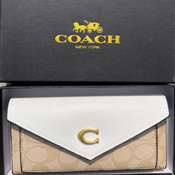 Coach wallet in signature canvas + white leather flap with gold logo.