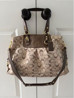 Coach Ashley Signature Carryall bag featuring beige monogram fabric and dark brown leather accents