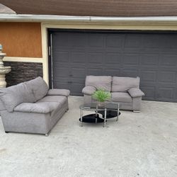 Beautiful two piece grey sofa set with glass table included asking 580 in great condition comfy and clean 