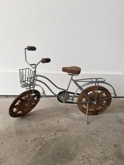 DecMode silver metal bike decorative sculpture with brown wood wheels.