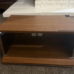 Compact wooden TV stand with glass doors, With Tires ideal for small spaces. 28"x15"x16" Furniture