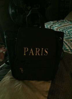 Black backpack purse has Paris on it