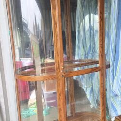  Lighted curved end curio cabinet with a mirrored back 