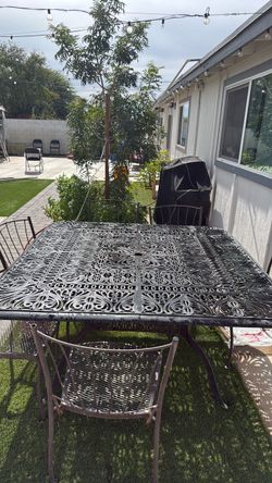 Large iron table w/ five metal chairs.