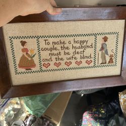 This is a framed, vintage cross-stitch sampler featuring a humorous saying about marriage. The piece is a type of needlework that was popular for home