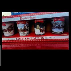 New, holiday 4 Budweiser limited edition pint glasses, original packaging. The glasses feature a holiday theme, making them a perfect addition to any 