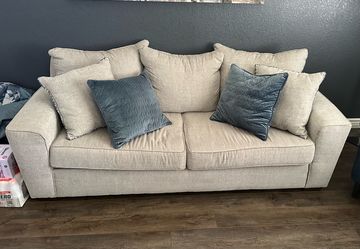 Beige two cushion sofa with pillows