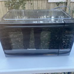 Small  microwave Kenmore countertop microwave in black.  Capacity: 0.7 cubic feet, ideal for small spaces like dorm rooms or offices Conditions excell