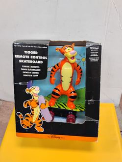 Vintage 1999 Disney Store Exclusive Tigger Remote Control Skateboard toy in its original black and orange packaging.