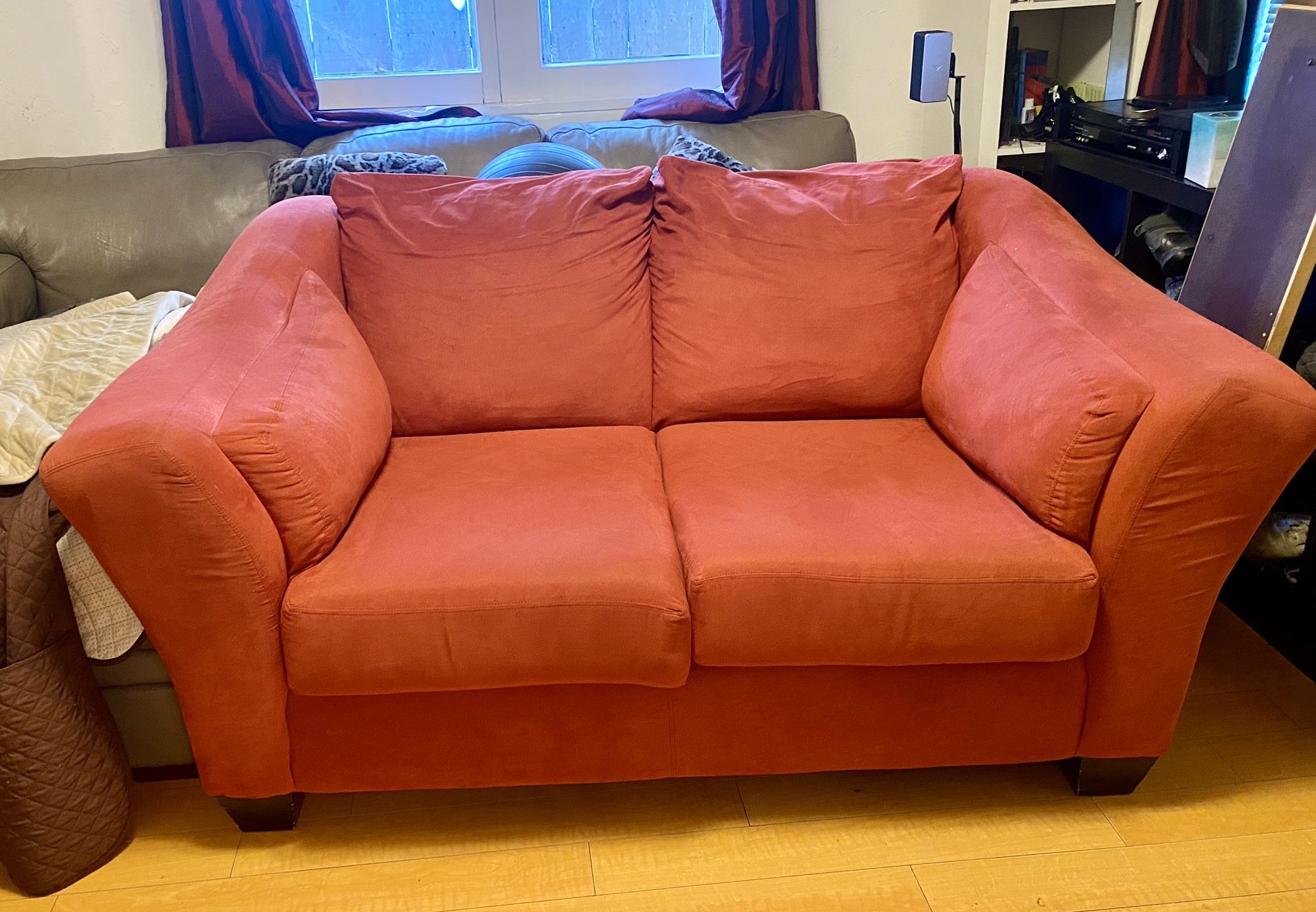 Red fabric loveseat with two protective couch sofa covers included 