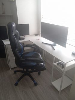 2 monitors, white desk with color lights and gaming chair.