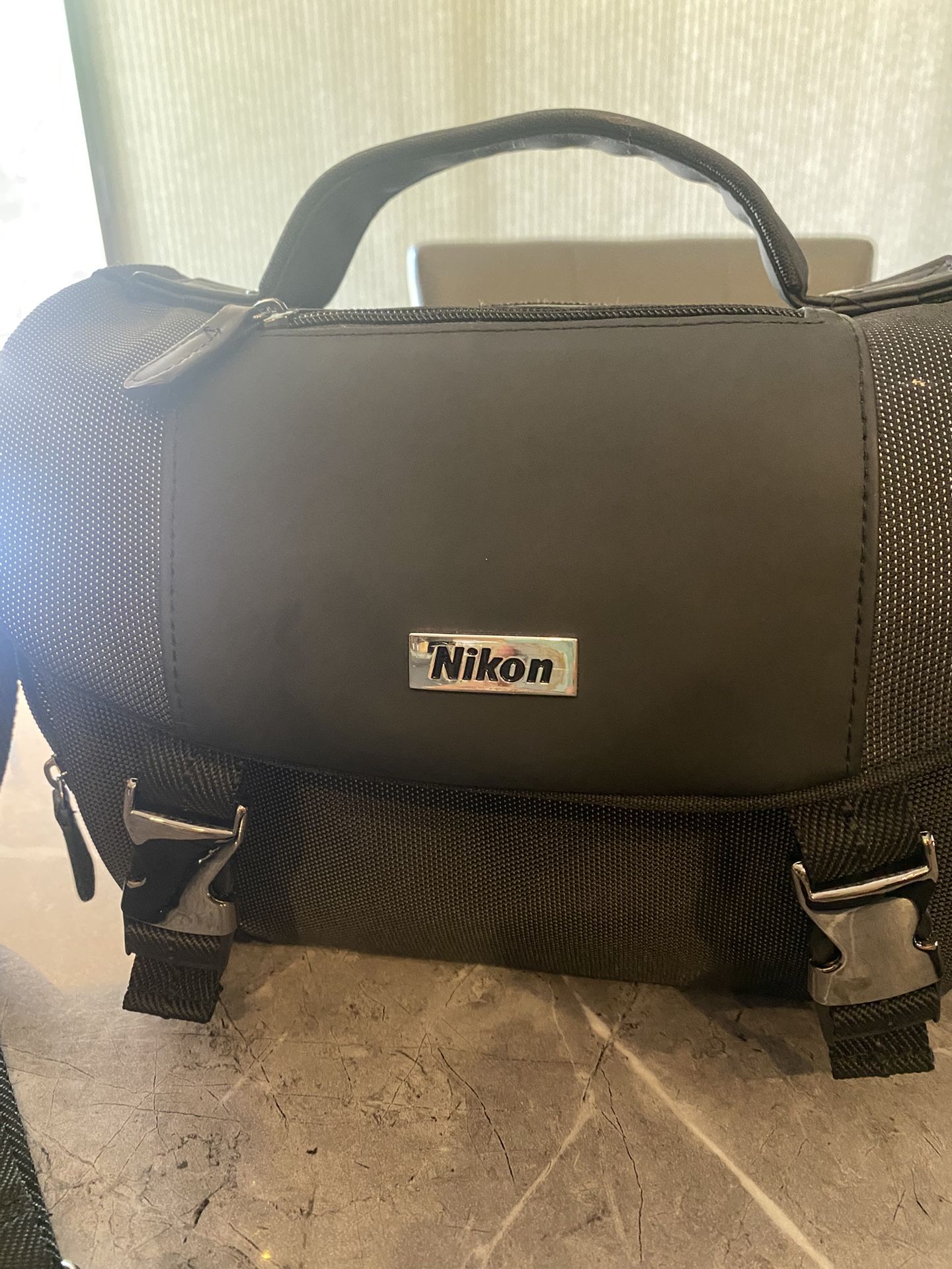 Nikon camera bag with handle and secure clasps.