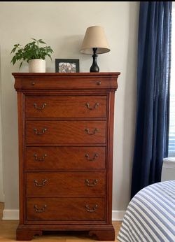 A beautiful, large solid wood dresser with six drawers.