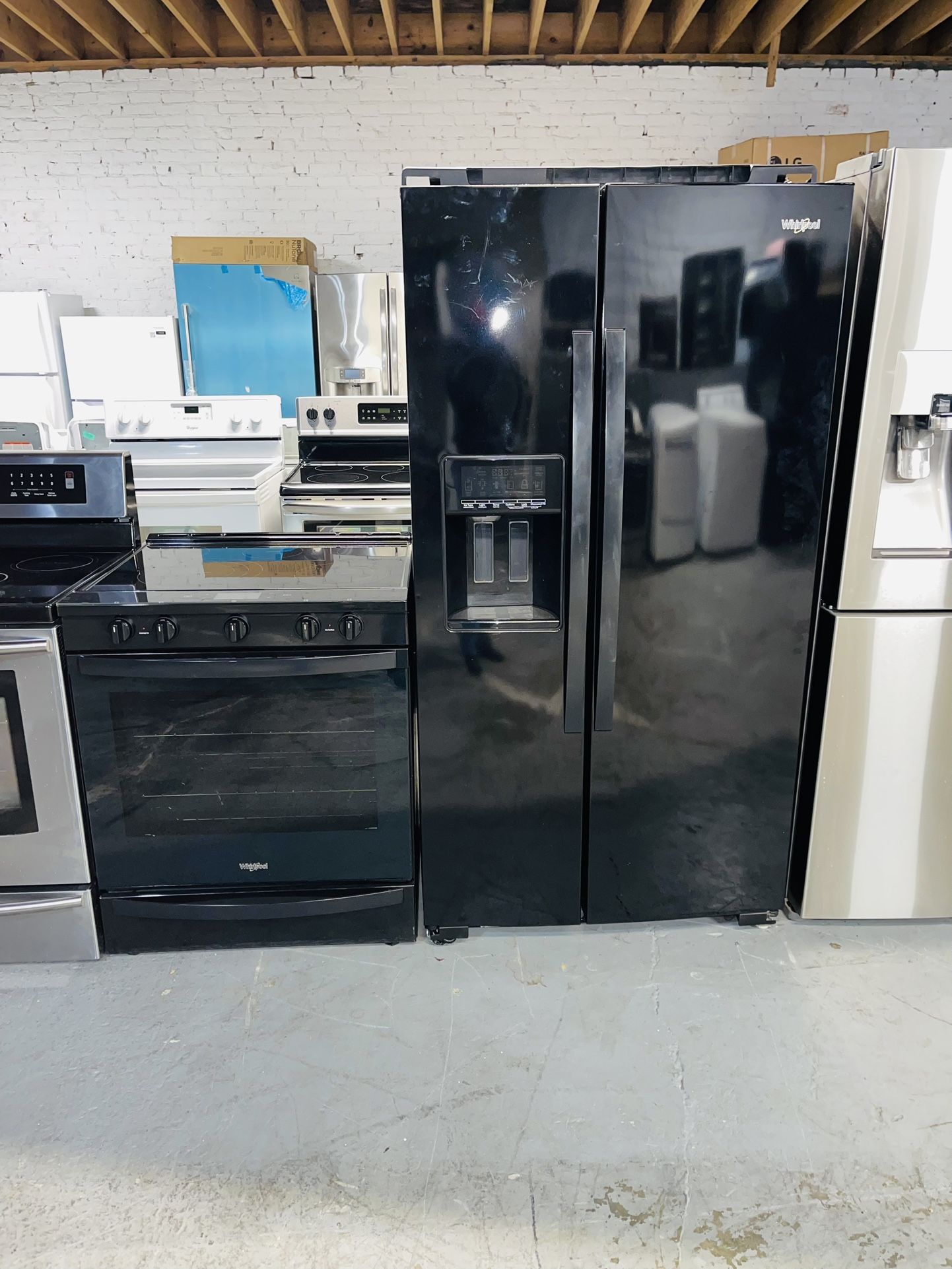 Whirlpool refrigerator, stove, dishwasher, and microwave, all black, with a receipt for a 60-day warranty.