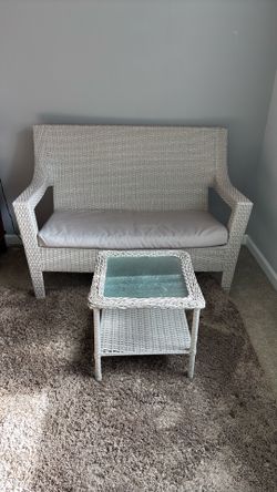 Wicker love seat with a matching coffee table