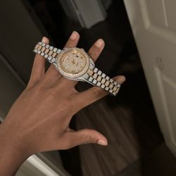 two-tone stainless steel iced-out moissanite watch with a baguette and round-cut stone bracelet.