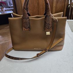 Michael Kors rust color purse wth snake accent on handle,strap and partial sides.  Size 15" w X  10" T.  Used but in great condition!